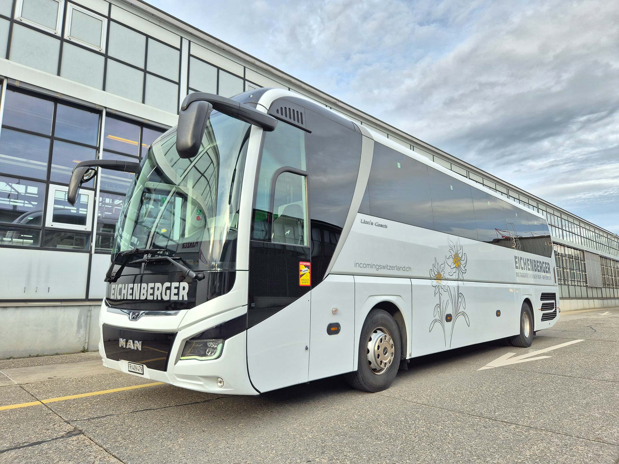 Moderner Reisebus vor Industriegebäude